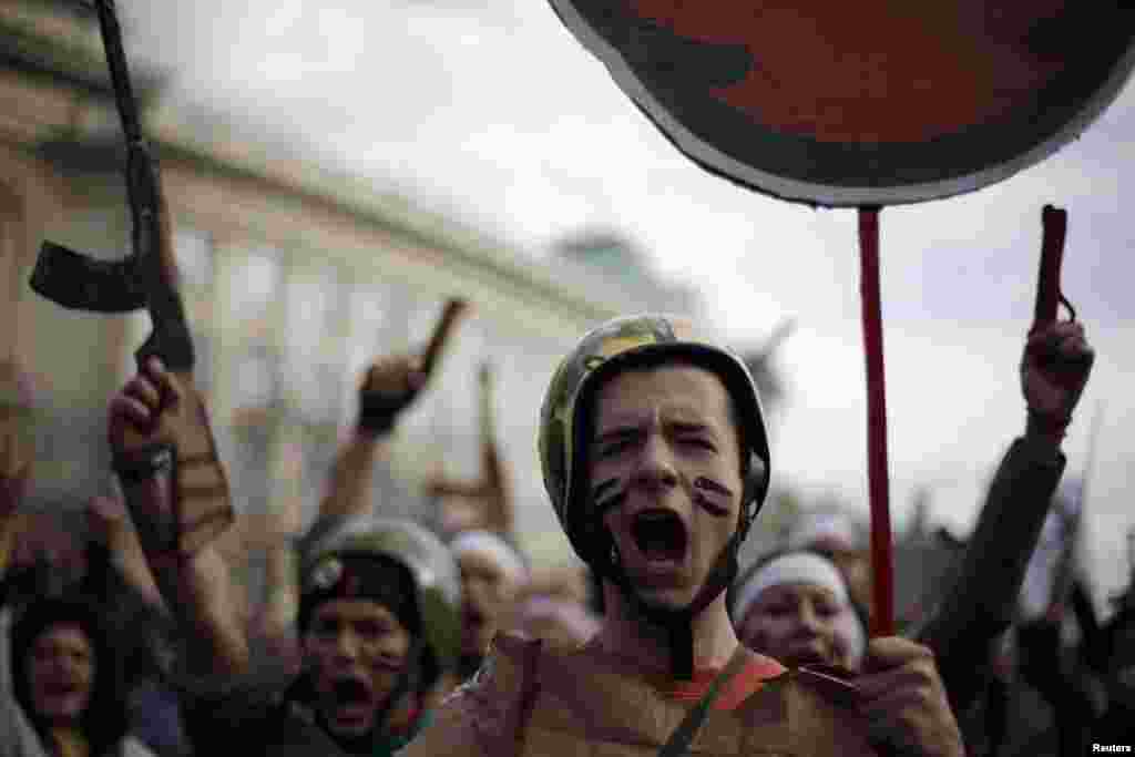 Mahasiswa protes sambil mengenakan seragam militer palsu dan meneriakkan slogan anti-pemerintah dalam demo di depan Universitas Sofia, Bulgaria, 20 November 2013. 