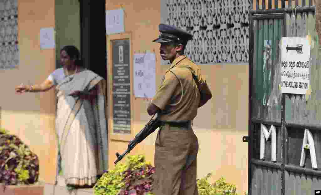 A Sri Lankan police officer stands guard at a polling station during the presidential elections in Colombo, Sri Lanka, Jan. 8, 2015. 