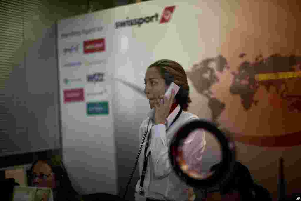 Petugas Swissport International, perusahaan pengelola kargo darat yang bermitra dengan Germanwings, di kantornya di Bandar Udara Barcelona, Spanyol (24/3). (AP/Emilio Morenatti)