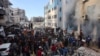 FILE - Orang-orang berkumpul saat asap mengepul dari sekolah PBB yang diubah menjadi tempat perlindungan setelah terkena serangan Israel, di lingkungan Rimal, Kota Gaza di Jalur Gaza utara, 14 November 2024.