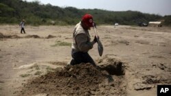 ARSIP – Seorang relawan menggali lokasi kuburan rahasia di Colinas de Santa Fe, negara bagian Veracruz, Meksiko, 30 Maret 2017 (foto: AP Photo/Felix Marquez, Arsip)