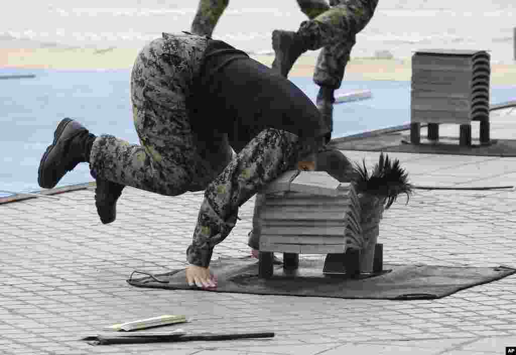 A soldier from the South Korean Army special forces breaks stone plates with her head during a martial arts demonstration for Memorial Day at Korea War Memorial Museum in Seoul.
