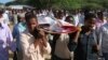 FILE - Somalis and local journalists carry the body of Moqtar Mohamed Hirab for burial in Mogadishu, Somalia.