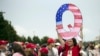 FILE - David Reinert holding a Q sign waits in line with others to enter a campaign rally with President Donald Trump in Wilkes-Barre, Pa. 