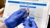 FILE - Nurse Kathe Olmstead prepares a shot that is part of a possible COVID-19 vaccine, developed by the National Institutes of Health and Moderna Inc., in Binghamton, New York, July 27, 2020.