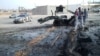 People inspect the site after a car bomb hit the convoy of Abdel-Razeq Nathouri, the chief of staff of the eastern Libyan military, outside Benghazi, Libya, April 18, 2018. 