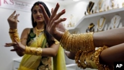 FILE - An Indian model displays gold jewelry during a Jewelry and Gem Fair in Hyderabad, India.