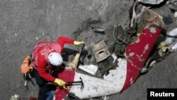 Un sécourist français inspecte les restes de l'A320 Germanwings Airbus sur le site de l'accident, près de Seyne-les-Alpes, Alpes françaises, le 29 Mars 2015.