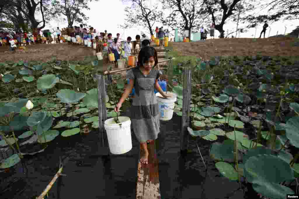 Orang-orang antri untuk mengambil air di danau Yazarthingyan di kota Dala, dekat Rangoon, Burma. Kota Dala yang terletak di dekat laut adalah satu-satunya sumber air tawar di kawasan itu. 