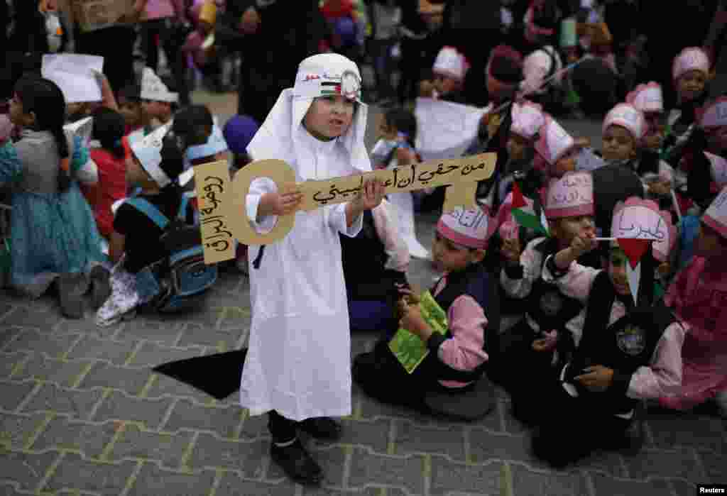Seorang anak laki-laki Palestina membawa simbol kunci yang bertuliskan &quot;Saya berhak untuk kembali ke rumah saya&quot; saat unjuk rasa di Khan Younis, Jalur Gaza.