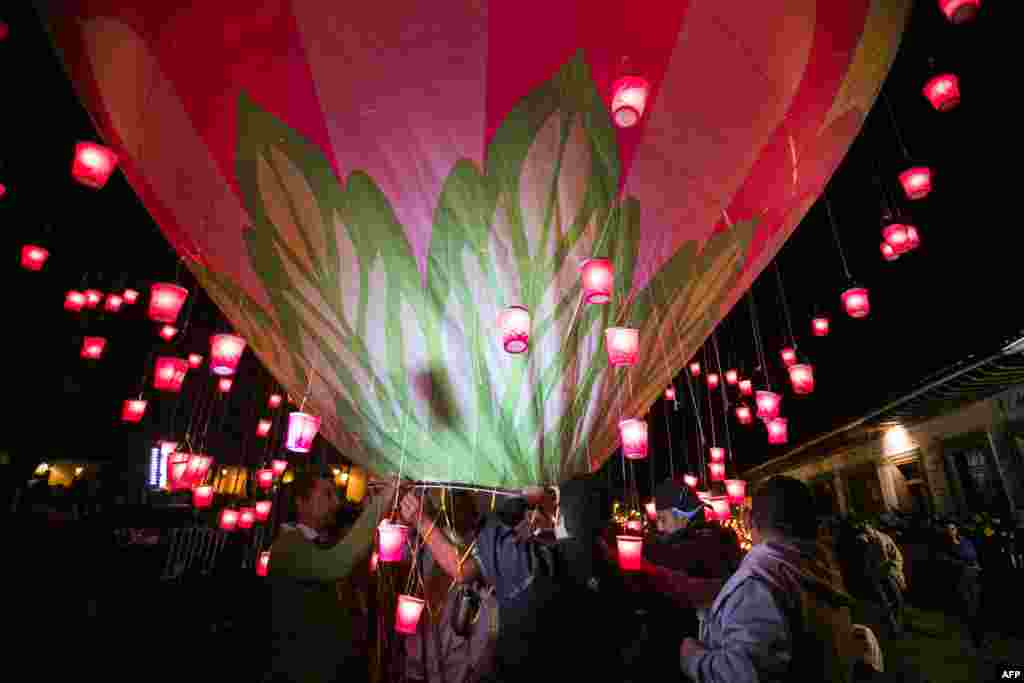 People rise balloons during the second day of the International Cantoya Festival in Patzcuaro, Michoacan State, Mexico.