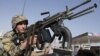 Afghan National army soldier takes on a weapon during a patrol near prayers gather for Eid al-Adha near a mosque in the outskirt of Jalalabad east of Kabul, Afghanistan, Oct. 26, 2012. 