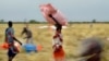 Des villageois collectent l'aide alimentaire larguée d'un avion dans un village du comté d'Ayod, au Soudan du Sud, le 6 février 2020. 