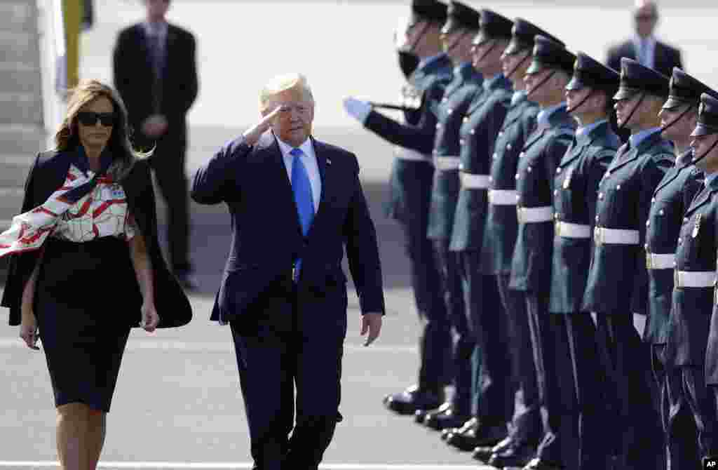 President Donald Trump salutes an honor guard as he and first lady Melania Trump arrive at Stansted Airport in England, June 3, 2019.