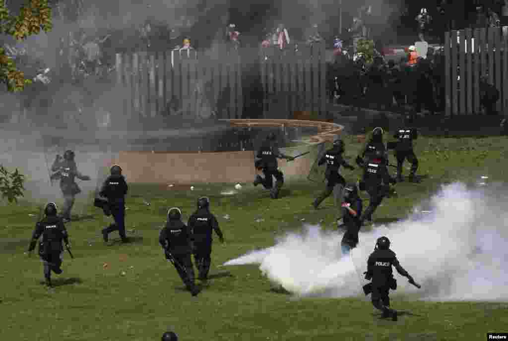 Riot police run after anti-government protesters trying to enter the Thai-Japan youth stadium in central Bangkok, Dec. 26, 2013. 