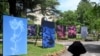 Visitors walk past photographs by French Marine Lanier as part of the exhibition "Hannibal's garden" on the opening day of "Les Rencontres d'Arles" photography festival in Arles, southern France, on July 1, 2024. 