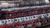 FILE - FILE - Brand new cars of German car manufacturer Volkswagen and BMW are parked on a freight train in Munich, Germany, Oct. 14, 2021. 