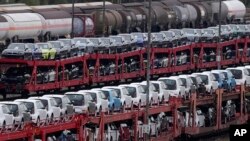 FILE - FILE - Brand new cars of German car manufacturer Volkswagen and BMW are parked on a freight train in Munich, Germany, Oct. 14, 2021. 
