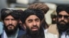 Taliban spokesman Zabihullah Mujahid, center, addresses a media conference at the airport in Kabul on Aug. 31, 2021.