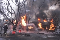 Firefighters try to extinguish a petrol tanker blaze, Aug. 10, 2019, in Morogoro, Tanzania.
