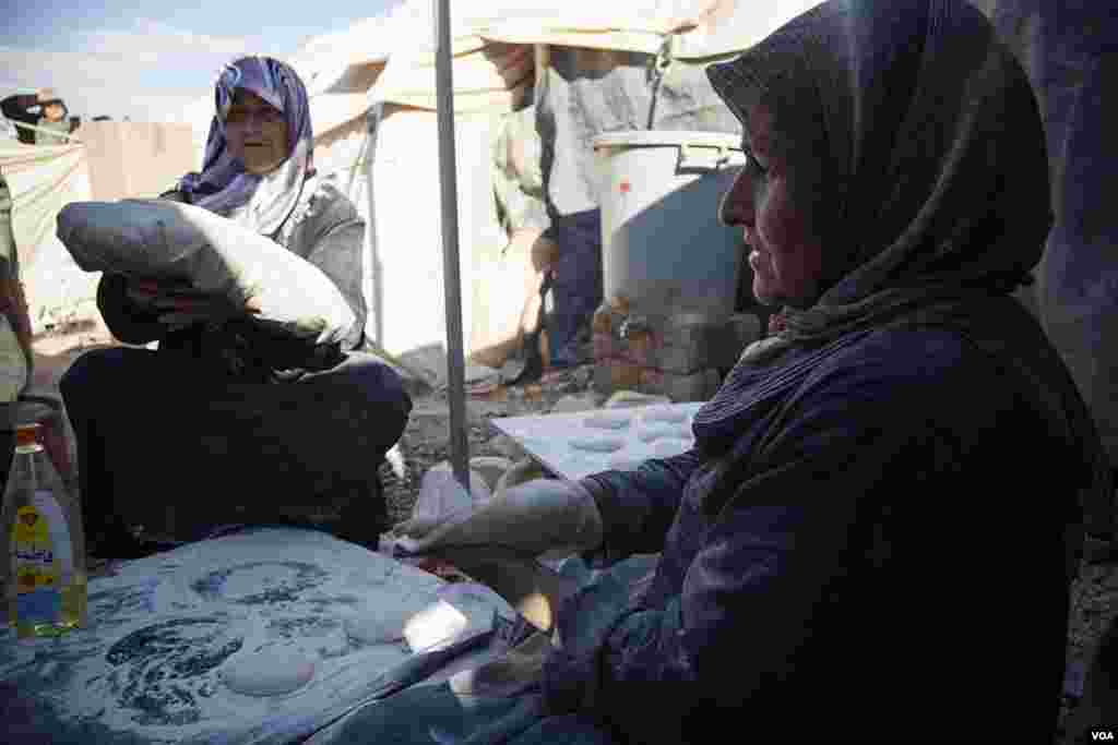 Syrian refugees make bread in a makeshift bakery between two tents in the Za'tari refugee camp. (Y. Weeks/VOA)