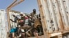 Les migrants montent dans un camion pour se diriger vers le nord en Algérie au poste frontière d'Assamaka, dans le nord du Niger, le 3 juin 2018.