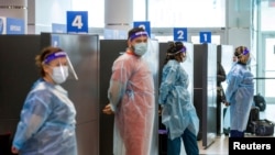 Para petugas kesehatan bersiap melakukan tes COVID-19 terhadap para penumpang yang tiba di Bandara Pearson, Toronto, Kanada, pada 1 Februari 2021. (Foto: Reuters/Carlos Osorio)
